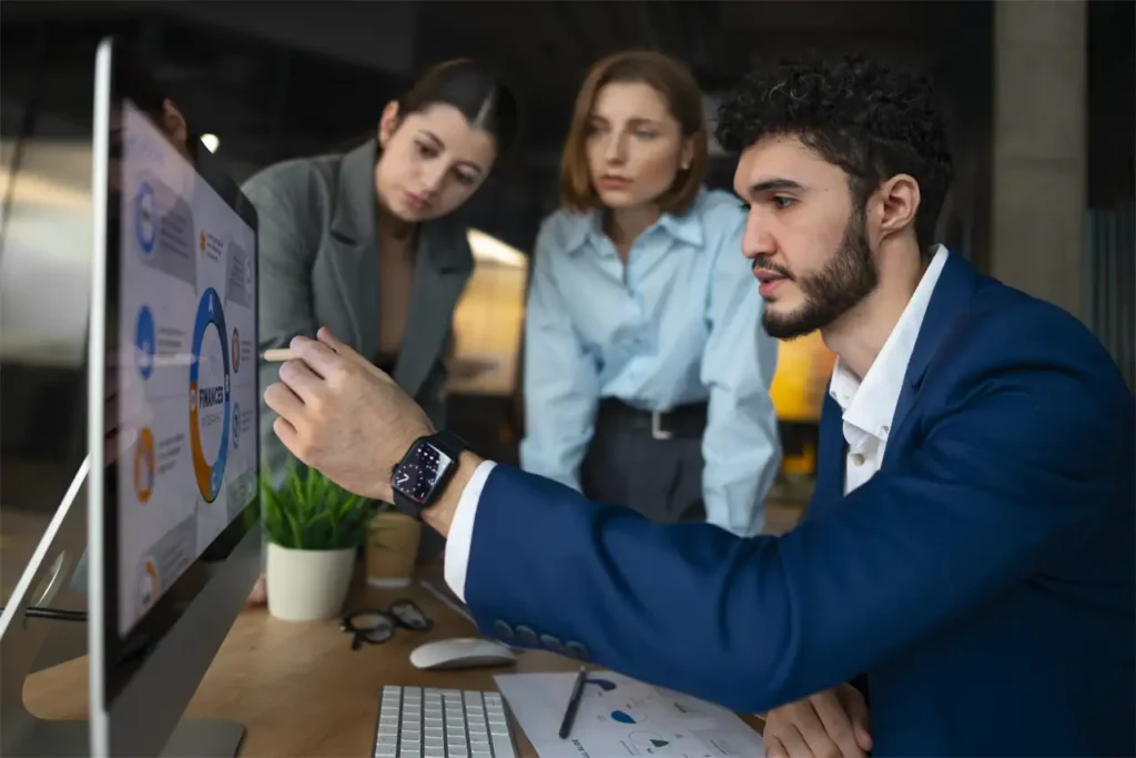 Equipo de trabajo colaborando frente a un computador
