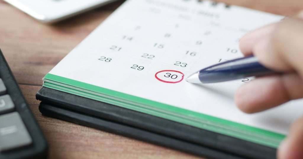 Backup job de Veeam: una mano marca una fecha en el calendario, como se programan las copias y su retención