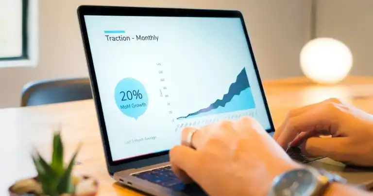 Animaciones en PowerPoint: unas manos sobre el teclado de un portátil que muestra una diapositiva con un gráfico de crecimiento y un porcentaje
