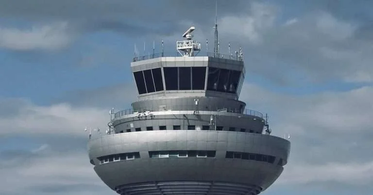 Azure PowerShell: la cabina de una torre de control de aeropuerto, con su radar y sus antenas, rodeada de nubes, como un solo punto desde el que se gobierna todo lo que hay en la nube