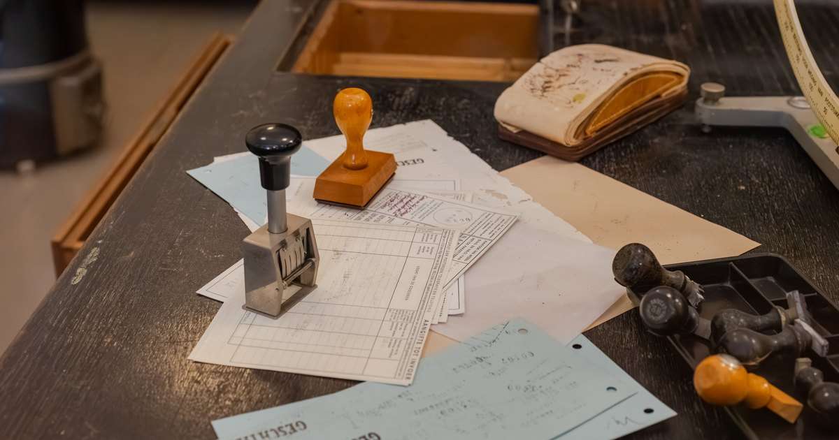 Plantillas en Outlook: mostrador de oficina con un sello de madera, un numerador y otros sellos de caucho sobre formularios impresos