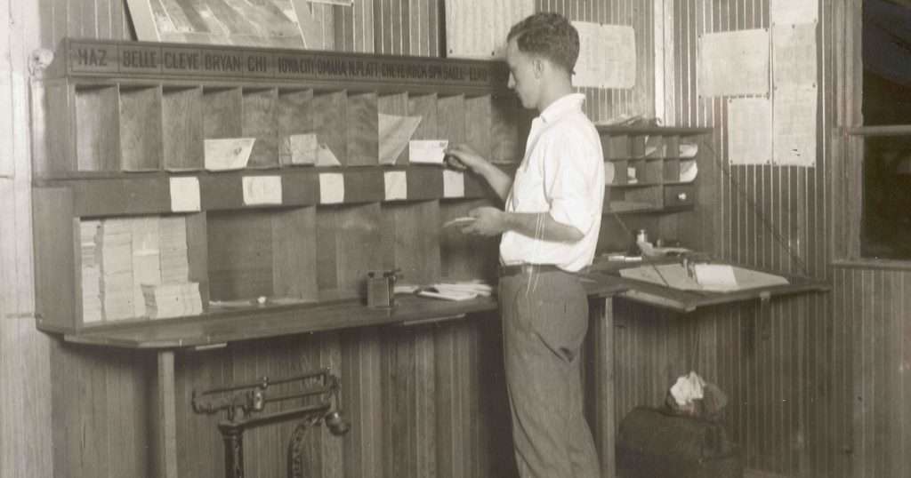 Reglas en Outlook: un empleado de correos de hacia 1920 reparte cartas en casilleros rotulados con el destino de cada una, como hace una regla con cada mensaje que llega