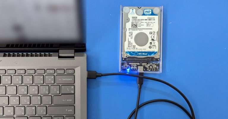 Robocopy sirve para copiar carpetas y subcarpetas a un disco externo como este: un disco duro de 2,5 pulgadas en una caja transparente, conectado por cable USB a un portátil