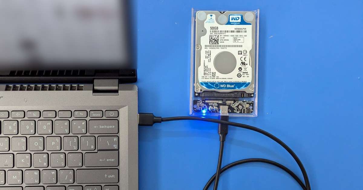 Robocopy sirve para copiar carpetas y subcarpetas a un disco externo como este: un disco duro de 2,5 pulgadas en una caja transparente, conectado por cable USB a un portátil