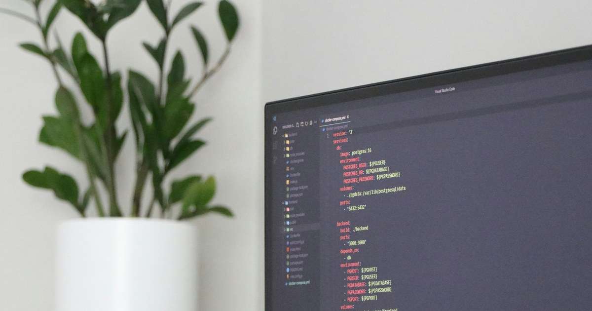 Traefik se configura en un archivo como este: monitor con un docker-compose.yml abierto, con los servicios de una aplicación y sus puertos, junto a una planta